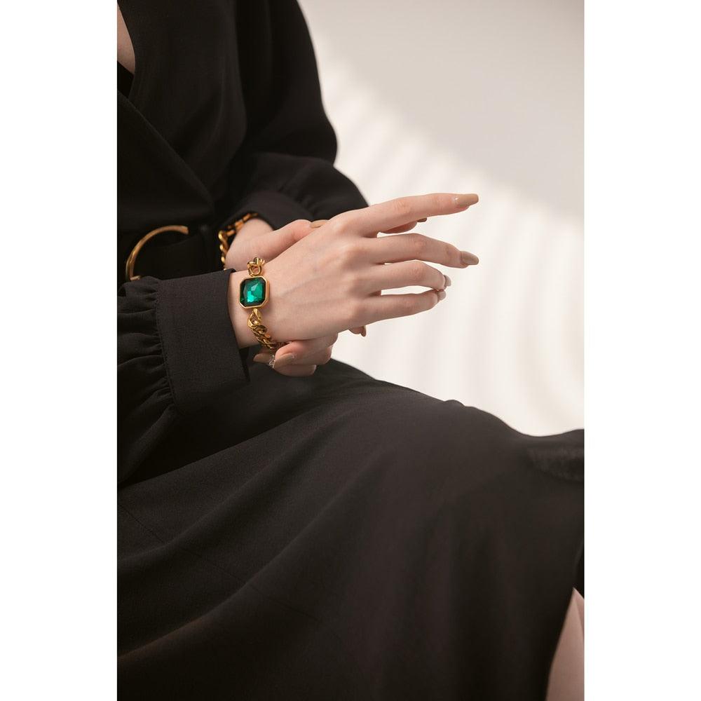 woman wearing gold plated bracelet jewelry with green crystal diamond